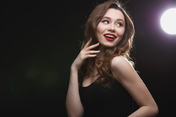 Happy charming young woman with red lips standing and smiling