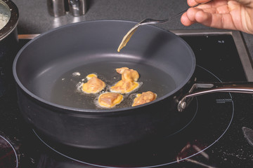 Cook frying chicken in a pan of oil
