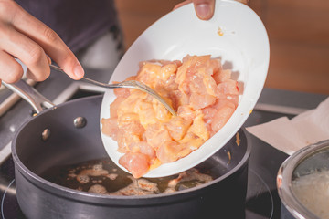 Cook frying chicken in a pan of oil