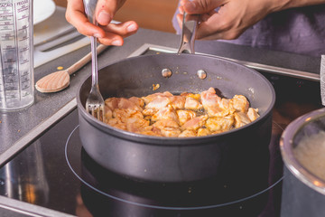Cook frying chicken in a pan of oil