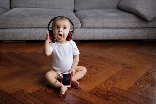 Sitting baby with headphones listening to music