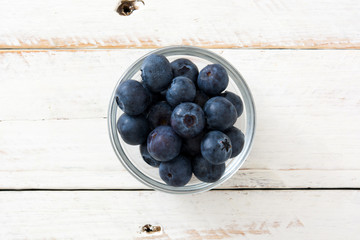 Blueberries in crystal bowl on white wooden background
