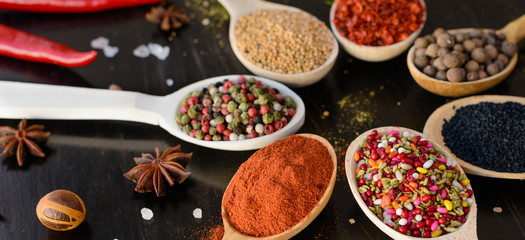 Obraz na płótnie Canvas Various spices on wooden spoons. Food ingredients