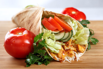 An appetizing chicken wrap with red onion and tomatoes