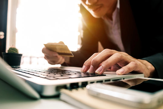 Business man hands using laptop and holding credit card with digital layer effect diagram as Online shopping concept