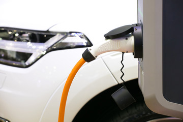 Power supply for electric car charging. Electric car charging station. Close up of the power supply plugged into an electric car being charged.