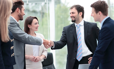 Two business people shaking hands at the business meeting with t
