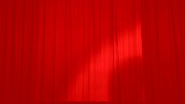 Theatrical red curtains of the stage. Stage drape covering the stage for the actors.