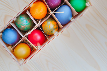 multicolored Easter eggs in wooden packing