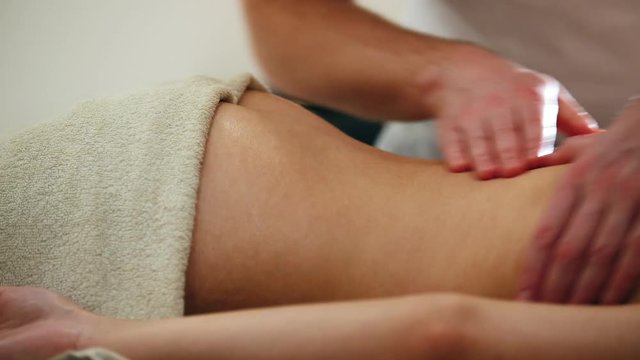 Close up view - Attractive young woman receiving massage at spa. Relaxation treatment for buttocks