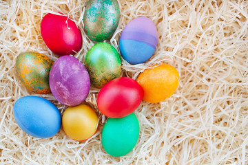 Fototapeta na wymiar Easter colored eggs on the hay