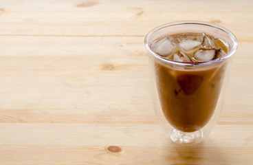 Ice coffee on the wooden background in morning time