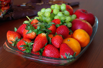 Fresh fruits in glass bowl on wooden table