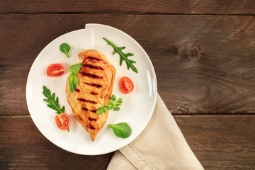 Grilled chicken fillet with cherry tomatoes and salad leaves