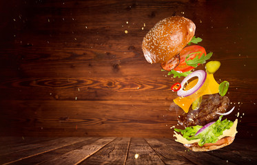 Big tasty burger with flying ingredients.