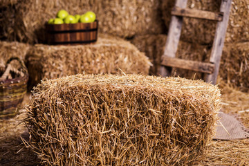 Bales of dry, golden hay lie in a wooden barn under a canopy. Farming and harvesting.Golden straw...