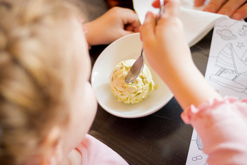 Obraz na płótnie Canvas Child eating ice cream. Kids enjoying sweet snack on a hot summer day. Children eat ice-cream. Little girl with pistachio ice cream