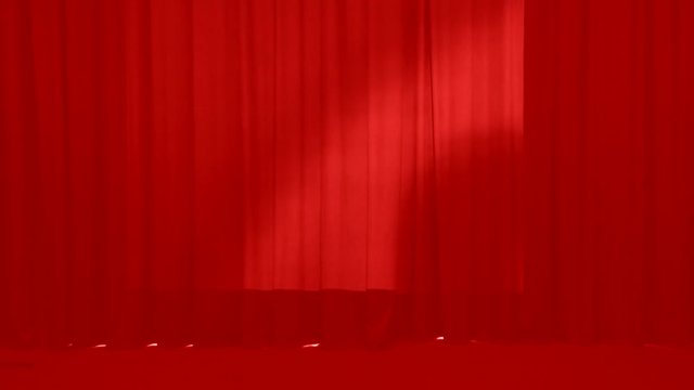 Theatrical red curtains of the stage closed. Stage drape covering the stage for the actors.