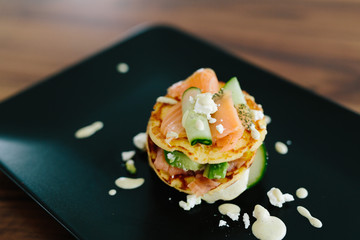 Gesunde Vorspeise mit Pfannkuchen, Lachs, Avocado und Gurken