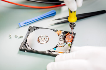 Obraz premium man repairing hard drive in service center. Repairing and fixing service in lab. Electronics repair service concept.