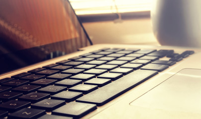 Daylight is punched through blinds at a window and falls on the keypad.