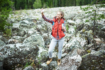 Naklejka na ściany i meble Young woman making her selfie during natural adventure