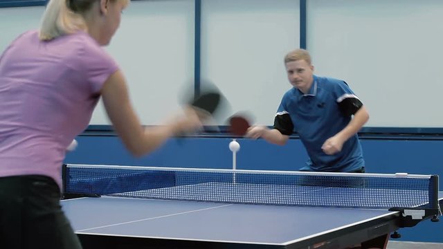 Young man and woman playing a table tennis