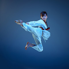 Young boy training karate on blue background © master1305