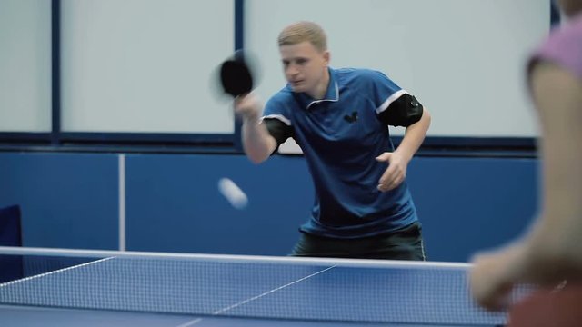Cute man and woman playing a table tennis at the court