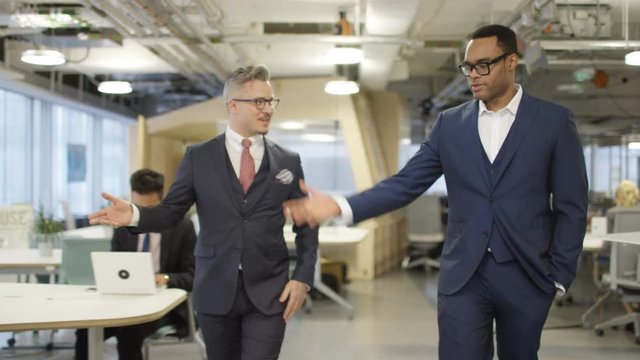  Smart executive business managers walking through modern office