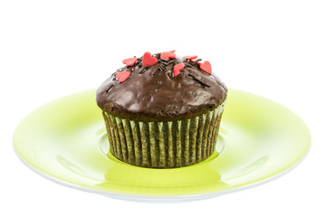 Isolated chocolate muffin on a green plate