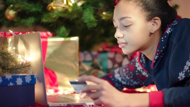 Close up shot of young black woman shopping online on Christmas Eve