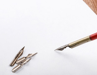 old calligraphy pen and nibs on white paper background