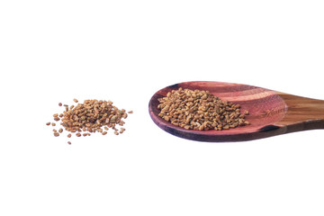 Fenugreek seeds on a brass spoon isolated on a white background.