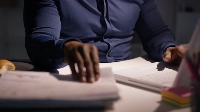  Overworked businessman working late is given extra pile of paperwork