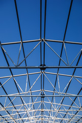 Galvanized steel roof truss construction frames with deep blue sky in the background