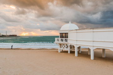 Obraz premium Romantic sunset at Cadiz beach with famous pier