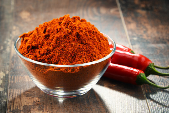 Composition With Bowl Of Chili Powder On Wooden Table