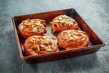 Freshly baked French raisin buns. Pains aux raisins on a vintage baking tray