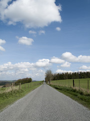 Fototapeta na wymiar Single lane country road through countryside and farmland