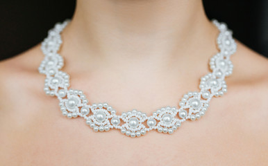 Jewelry concept. Closeup portrait of a wedding necklace on female neck