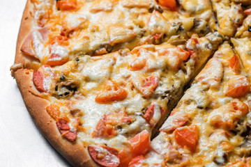 pizza with sausage, by cut to pieces on a metal table. selective focus on the filling close-up.