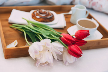 Breakfast in bed with coffee and flowers 
