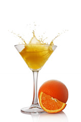 Fototapeta na wymiar Splash in glass of yellow alcoholic cocktail drink with orange