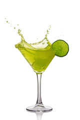 Splash in glass of green alcoholic cocktail drink with lime