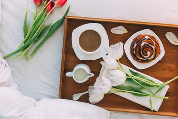 Breakfast in bed with coffee and flowers 