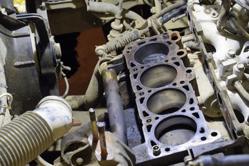 The cylinder block of the four-cylinder engine. Disassembled motor vehicle for repair. Parts in engine oil. Car engine repair in the service