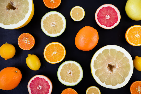 Lemon, orange, mandarin, grapefruit and sweetie on dark background. Flat lay, top view. Fruit background