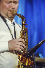 Fototapeta premium A handsome man of 30-40 years of European appearance plays the saxophone.