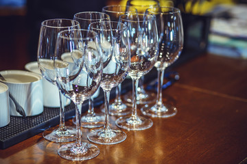 Wine glasses stand on the bar.